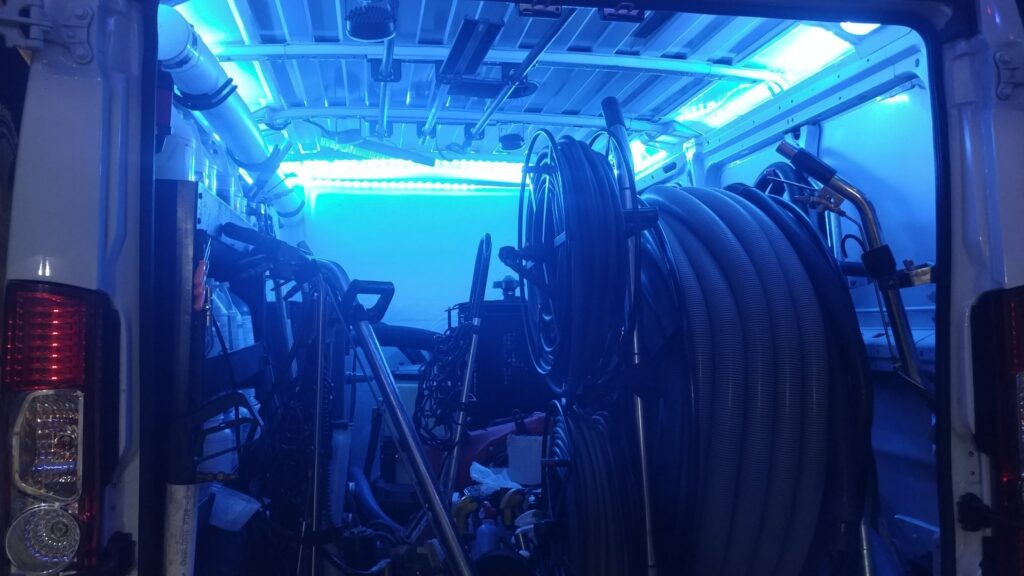 Interior of a Cleaning Service Pro, LLC van with blue lighting, showing coiled hoses and carpet cleaning equipment in Peoria, AZ