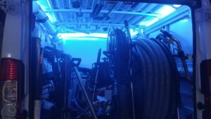 Interior of a Cleaning Service Pro, LLC van with blue lighting, showing coiled hoses and carpet cleaning equipment in Peoria, AZ