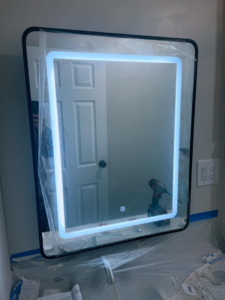 An illuminated LED mirror being installed by Revamp Athens Electrical Company in Athens, GA.