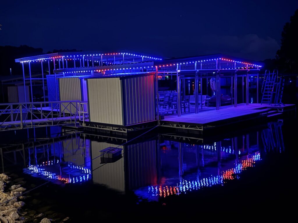 A long, illuminated walkway or bridge with lights installed along the railings by Get Lit KC & LOZ in Kansas City, KS.