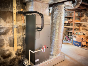 An indoor air handler and insulated ductwork installed in a basement by ComfortCool Mass in Quincy, MA