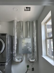 An indoor air handler unit with insulated ductwork installed in a laundry room by A's Heating and Cooling LLC in Portland, OR.