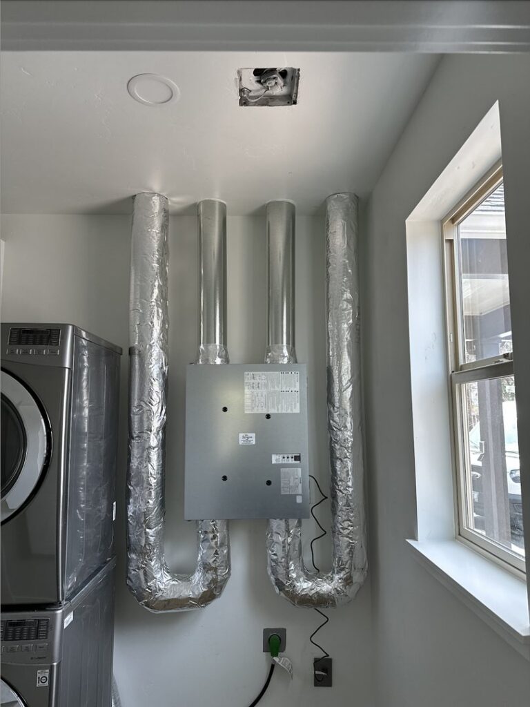 An indoor air handler unit with insulated ductwork installed in a laundry room by A's Heating and Cooling LLC in Portland, OR.