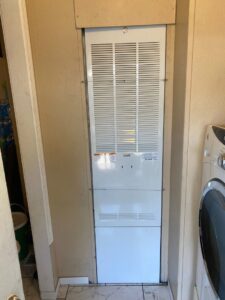 A tall indoor air handler unit installed in a utility closet by LUCAS Heating And Air LLC in Salt Lake City, UT.