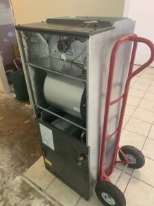 An indoor air handler unit on a dolly, ready for installation or removal by Netherland Air Conditioning LLC in Mobile, AL.