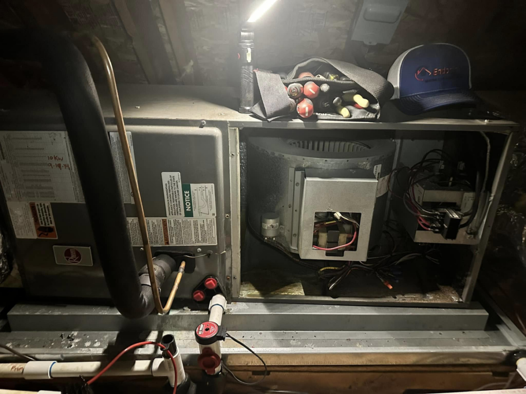 An indoor air handler unit with tools nearby, indicating service by EndorFin Service's Inc. Heating & Air Conditioning in Gloucester, VA.