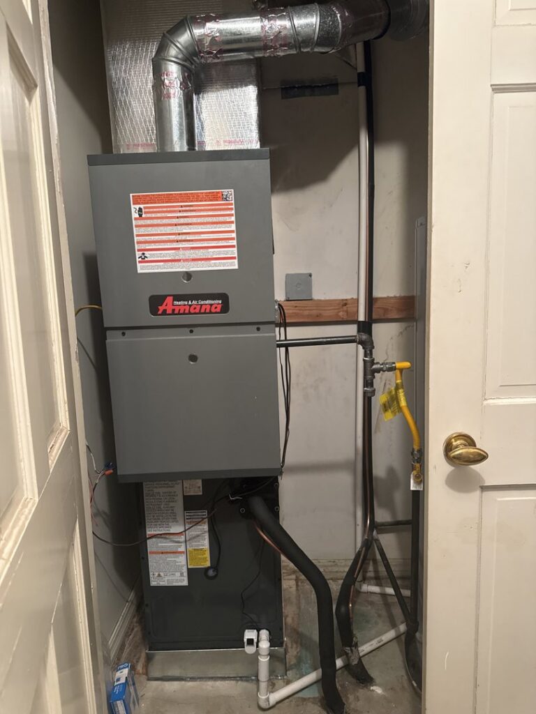 An indoor Amana furnace or air handler unit installed in a utility closet by Chill Out Heating and Cooling in Tulsa, OK.