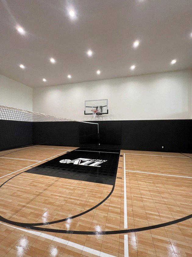 An indoor basketball court illuminated by numerous recessed ceiling lights installed by Homestead Electric in Orem, UT.