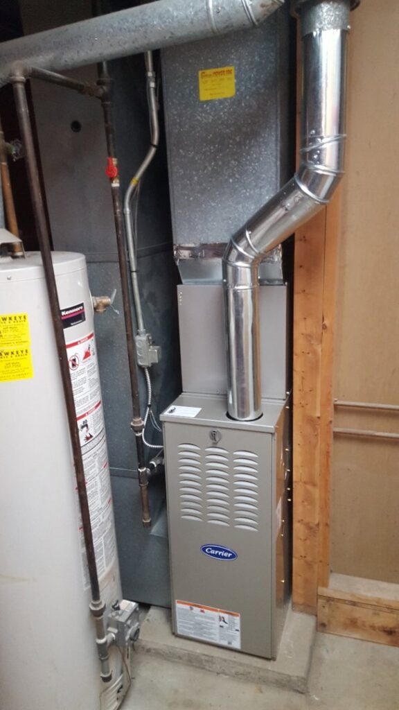 An indoor Carrier furnace and ductwork installed in a utility room by Custom Climates in Iowa City, IA.