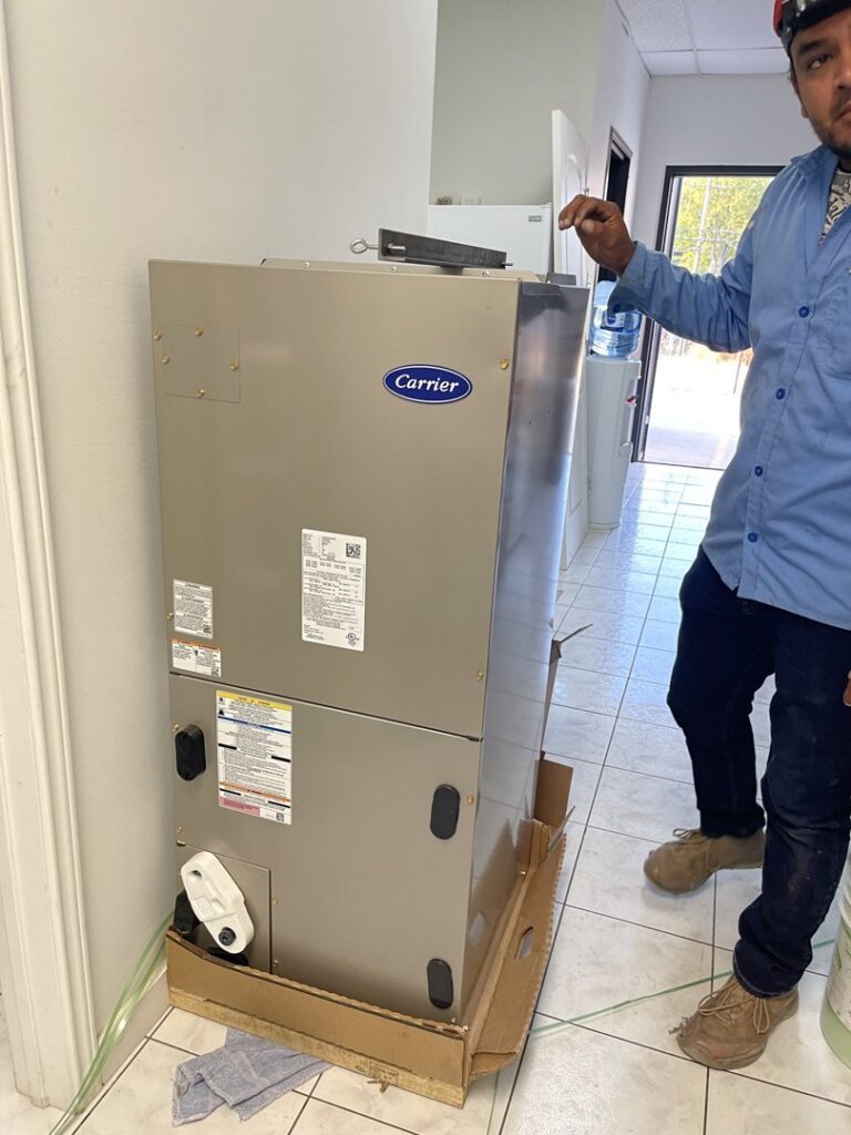 A technician installing or servicing an indoor Carrier HVAC air handler unit for BV Air Conditioning & Heating in Dallas, TX.