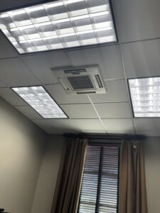 An indoor ceiling-mounted HVAC cassette unit installed in an office by Alpha HVAC LLC in Alexandria, LA.