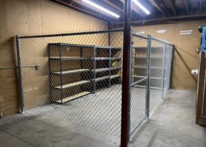 An indoor chain link security enclosure with shelving, installed by The GateKeeper Perimeter Fence & Automated Security in Sioux Falls, SD