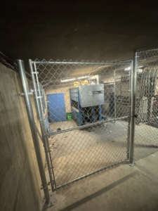 An indoor chain-link gate, part of a security enclosure, expertly installed by Littleton Construction LLC in the Service Area.