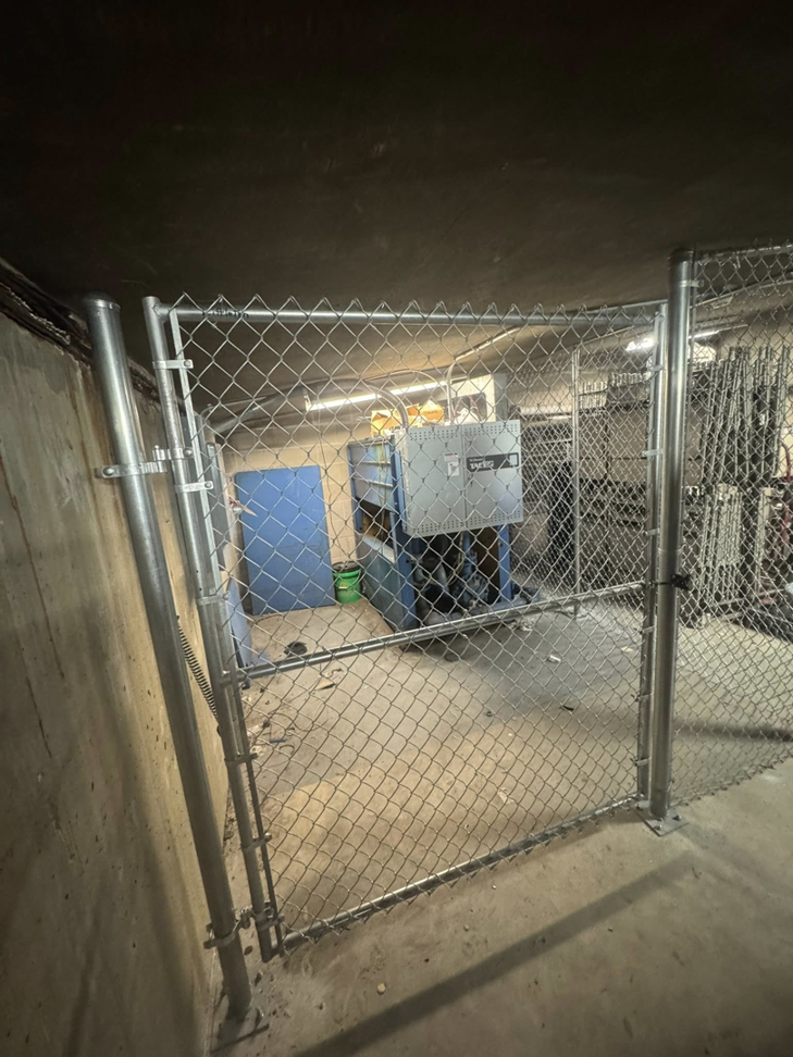 An indoor chain-link gate, part of a security enclosure, expertly installed by Littleton Construction LLC in the Service Area.
