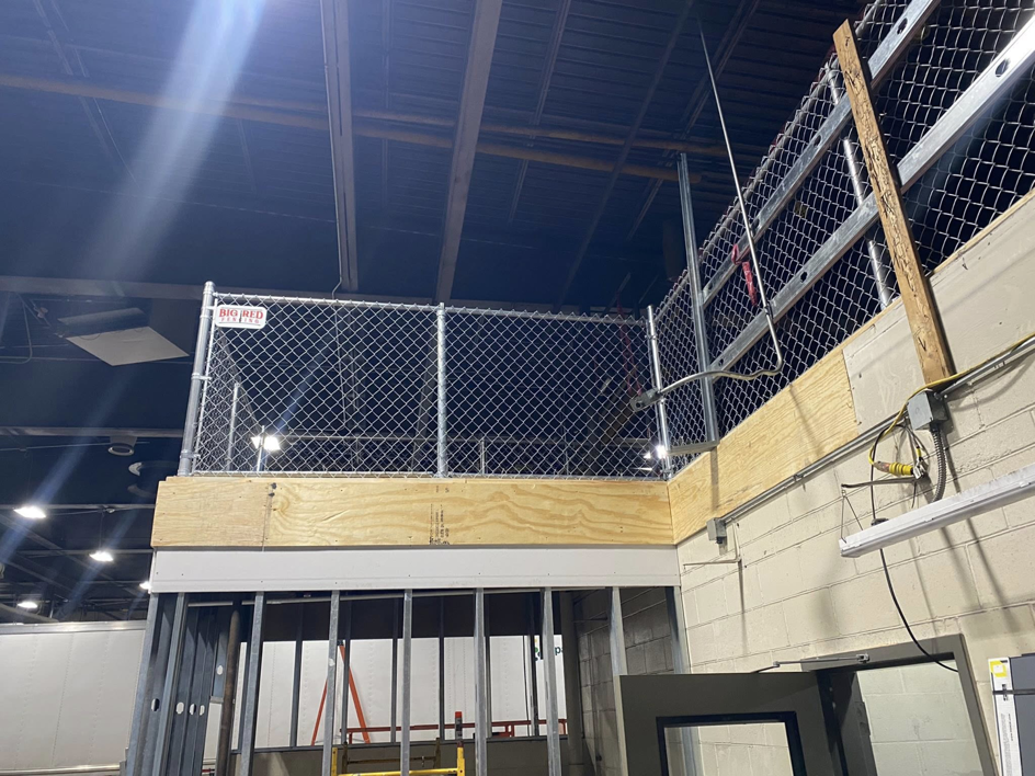 An indoor chain-link safety fence installed on an elevated platform by Big Red Fencing LLC in Waverly, NE.