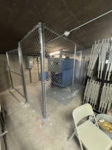 An indoor chain-link security enclosure constructed by Littleton Construction LLC for commercial use in the Service Area.