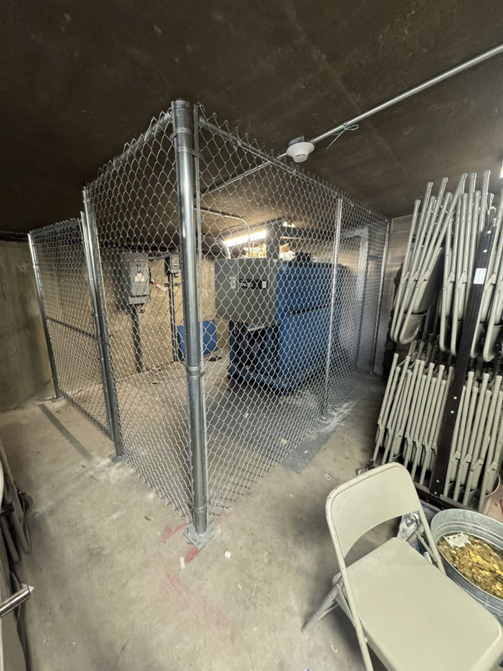 An indoor chain-link security enclosure constructed by Littleton Construction LLC for commercial use in the Service Area.