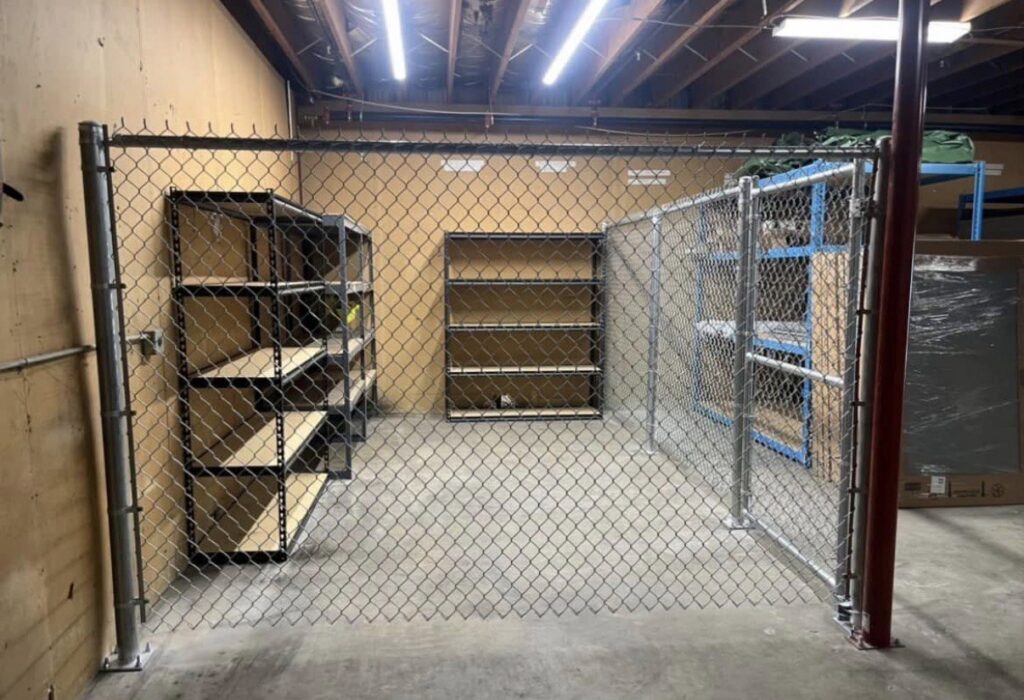 An indoor chain link security fence enclosure with a gate, installed by The GateKeeper Perimeter Fence & Automated Security in Sioux Falls, SD