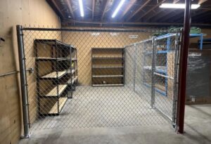 An indoor chain link security fence enclosure with a gate, installed by The GateKeeper Perimeter Fence & Automated Security in Sioux Falls, SD