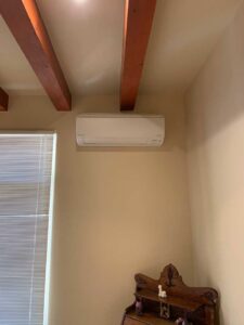 An indoor Daikin mini-split unit installed on a beige wall near a window by Jerome's Mechanical, LLC in Santa Fe, NM