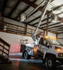 Lumenus Technologies, LLC performing indoor electrical maintenance with a bucket truck in Lenexa, KS.