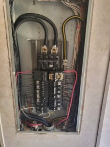 An open indoor electrical panel with numerous circuit breakers and wiring, showcasing work by Delta Electric in Germantown, MD.