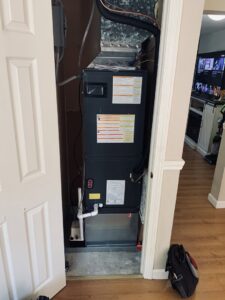 An indoor furnace and air handler unit installed in a closet by Elite Heating and Cooling in Livonia, MI.