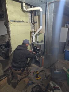 An indoor furnace and air handler unit with connected ductwork, representing heating services by 24/7 Heating & Air, LLC in Grand Island, NE.