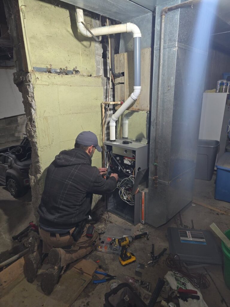 An indoor furnace and air handler unit with connected ductwork, representing heating services by 24/7 Heating & Air, LLC in Grand Island, NE.