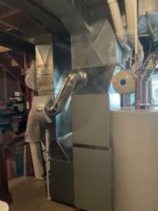 An indoor furnace and air handler unit with connected ductwork, installed by A-Team PHC in Olathe, KS.