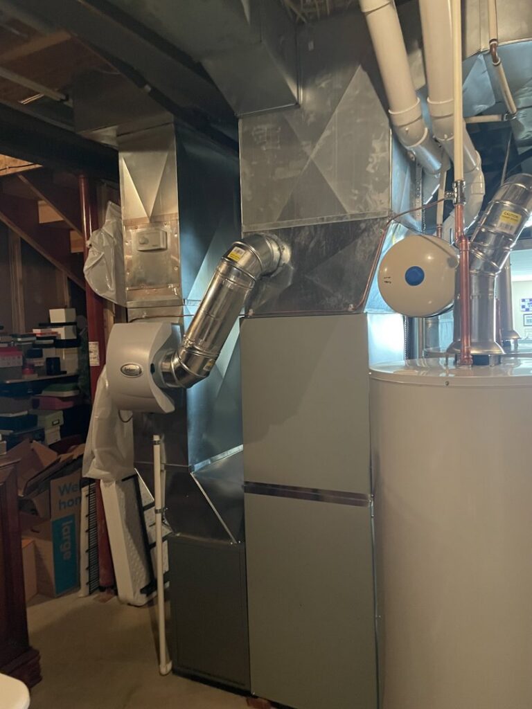An indoor furnace and air handler unit with connected ductwork, installed by A-Team PHC in Olathe, KS.