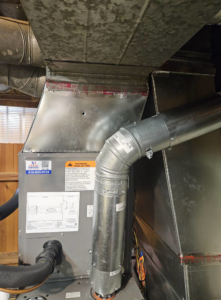 An indoor furnace and air handler unit with connected ductwork, serviced by Astron Services LLC in Wichita, KS.