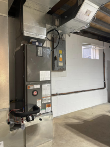 An indoor furnace and air handler unit with connected ductwork in a utility space, installed by Force Mechanical Services in Churchville, MD.