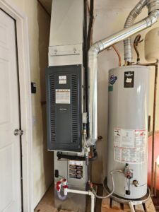 An indoor furnace and air handler unit installed next to a water heater by ABC Mechanical Inc in Lawrenceville, GA.