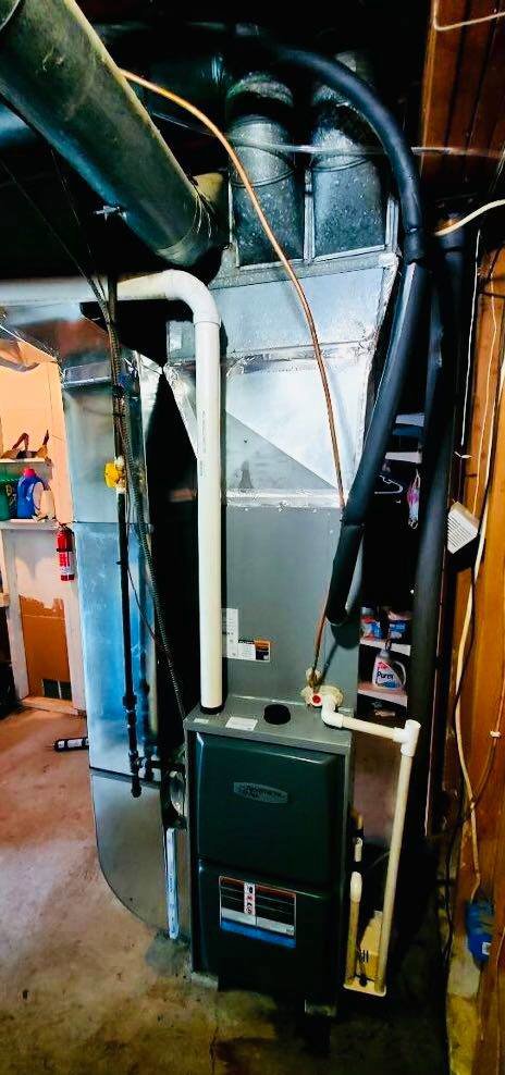 An indoor furnace and air handler unit with connected ductwork, representing an HVAC installation by Adams Heating and Cooling in Schenectady, NY