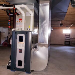 An indoor furnace and air handler unit with connected ductwork in a basement, installed by Allied Heating and Air Conditioning in Port Richey, FL.