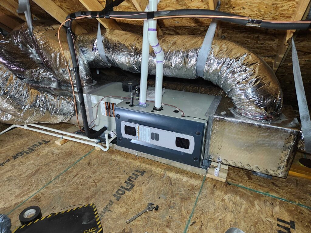 An indoor furnace and air handler unit with ductwork installed in an attic by OKIE Heating and Cooling in Tulsa, OK.