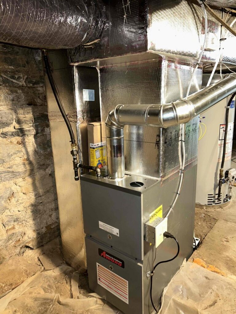 An indoor furnace and air handler unit with new ductwork installed in a basement by One Hour Heating & Air Conditioning of Lancaster, PA.