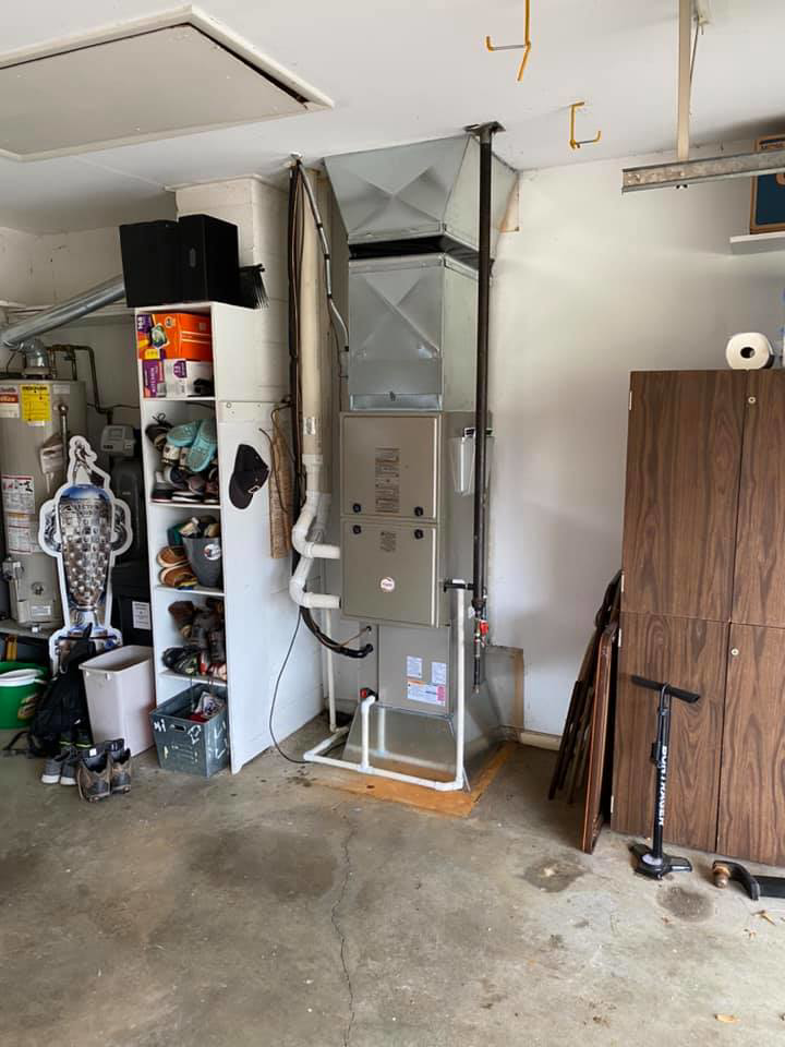 An indoor furnace and air handler unit with ductwork installed in a garage by R. Jones Heating & Cooling in Indianapolis, IN.