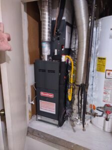 An indoor furnace and air handler unit installed in a utility closet by Manuel & Sons Service Co. in San Antonio, TX.