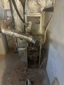 An indoor furnace and air handler unit with exposed ductwork, undergoing repair by EndorFin Service's Inc. in Gloucester, VA.