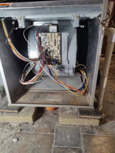 An indoor furnace or air handler unit with its panel open, showing wiring and circuit board, serviced by PNW Spokane Heating and Air in Spokane, WA.