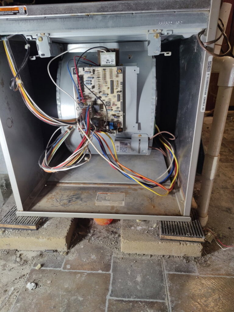 An indoor furnace or air handler unit with its panel open, showing wiring and circuit board, serviced by PNW Spokane Heating and Air in Spokane, WA.