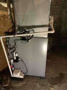 An indoor furnace and air handler system with visible piping and electrical connections by Great Lakes Heating & Air Conditioning in Wickliffe, OH.
