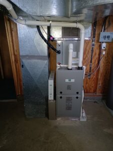 An indoor furnace and air handler unit with ductwork in a basement, installed by Ridgeline Heating and Cooling in Idaho Falls, ID.