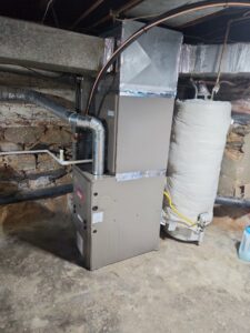 An indoor furnace and air handler unit with ductwork in a basement, installed by HVAC Philly in Feasterville, PA.