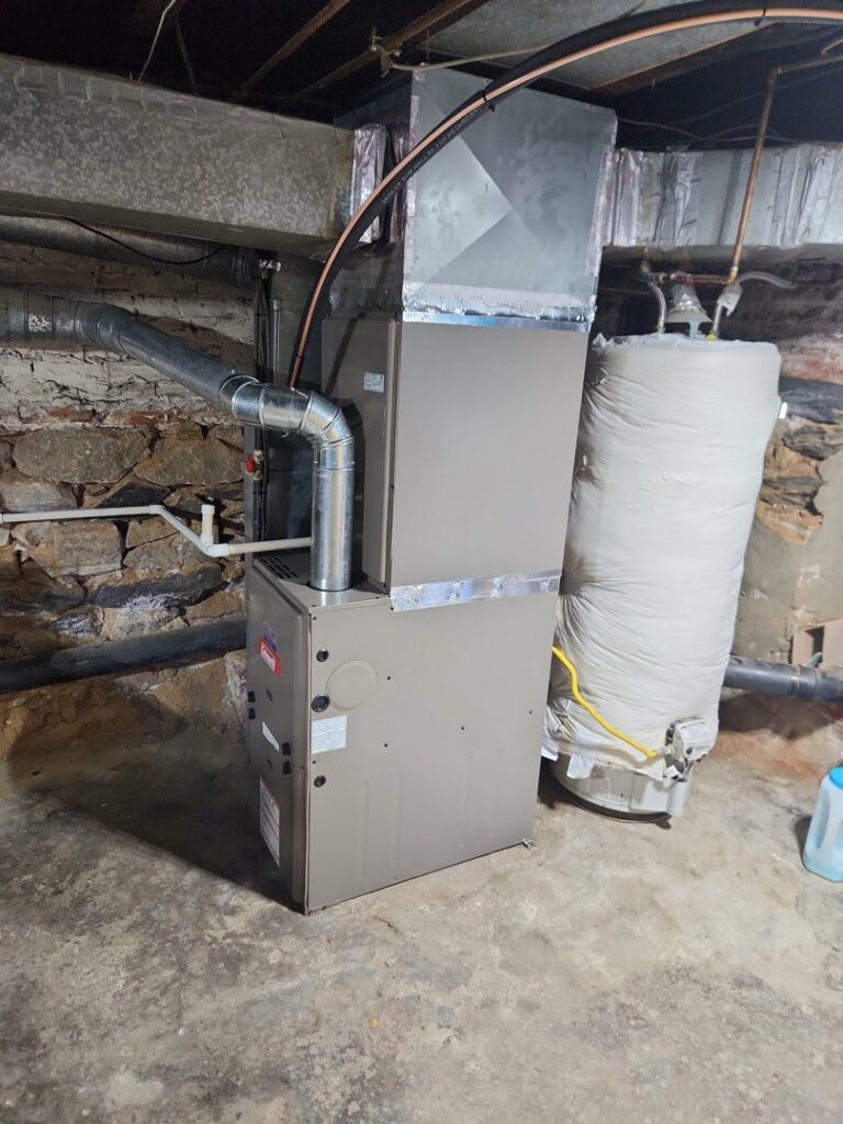 An indoor furnace and air handler unit with ductwork in a basement, installed by HVAC Philly in Feasterville, PA.