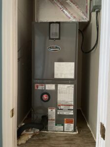 An indoor furnace and air handler unit installed in a utility closet by Total Living Comfort in Irvington, AL.