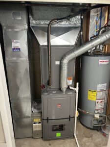 An indoor furnace and water heater unit with associated ductwork installed by Peterson Heating & Cooling in Mound City, KS.