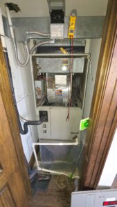 An indoor furnace or air handler unit undergoing diagnostic testing with a multimeter by Bruce Heating & Air in Kennewick, WA.